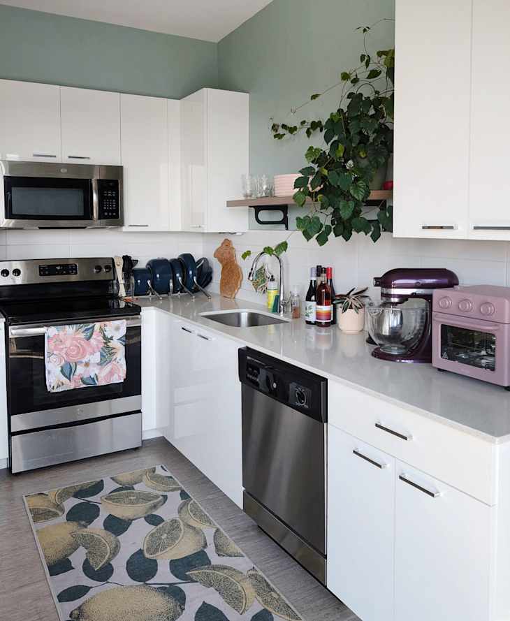 White cabinets in green painted kitchen.