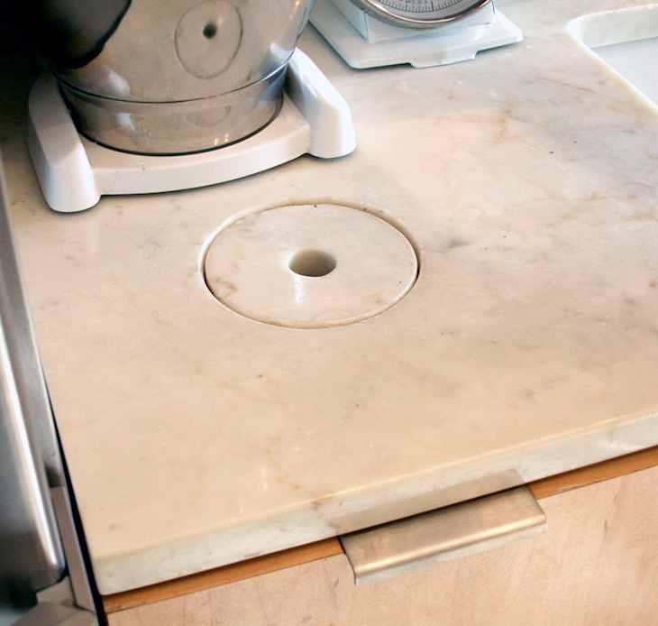 Marble countertop with a built-in mixer lift and a circular cutout.