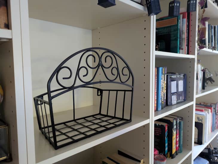 Hose holder on bookshelf.