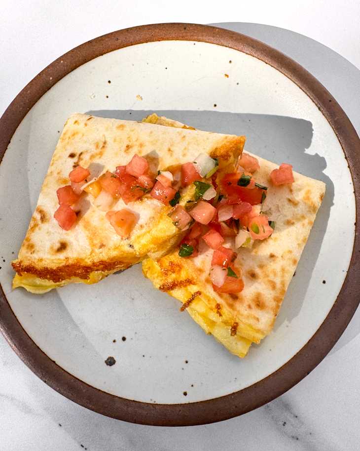 Breakfast quesadilla cut in half on plate