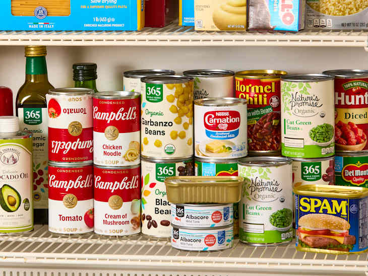 head on shot of an assortment of canned pantry items on white wire pantry shelves.