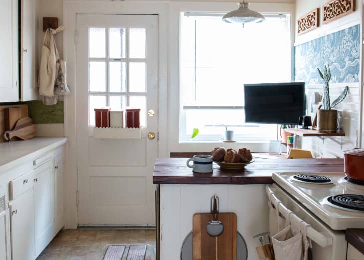 A white kitchen with a wooden kitchen counter/DIY standing desk