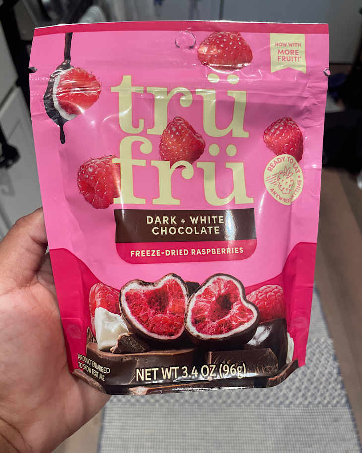 Someone holding a bag of tru fru freeze dried raspberries.