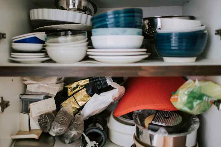 Cabinet storage with plates , bowl and dairy product in domestic kitchen