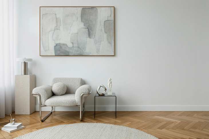 Modern lounge area with a boucle armchair, artistic decor, and soft textures. Neutral tones emphasize calm and sophistication.