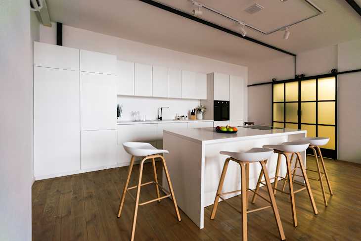 Kitchen in new luxury home with quartz waterfall island, hardwood floors, dark wood cabinets, and stainless steel appliances
