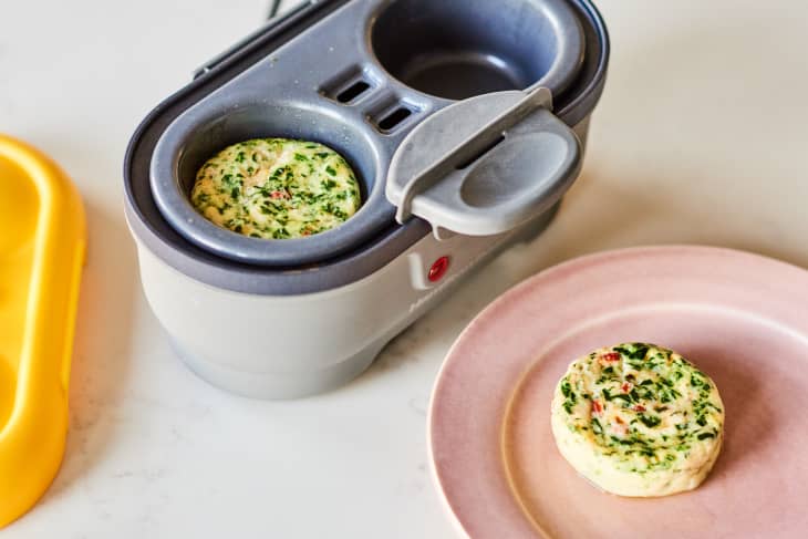 Egg bite with spinach and red peppers in a cooker and on a pink plate.