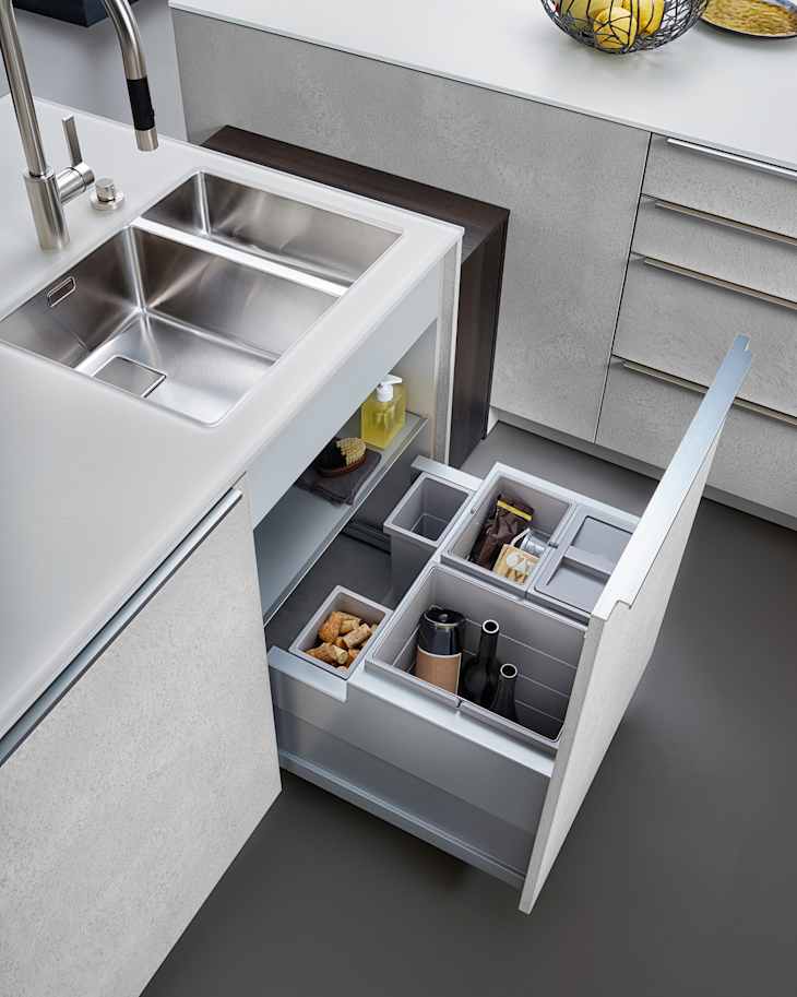 Modern kitchen, Open pull out drawers, Sink waste bin in kitchen drawer. Stainless steel drawer box side.