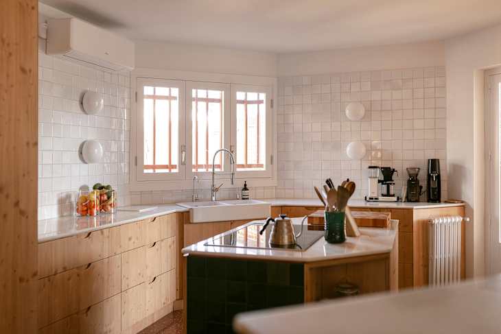 White tile in kitchen with wooden cabinets.
