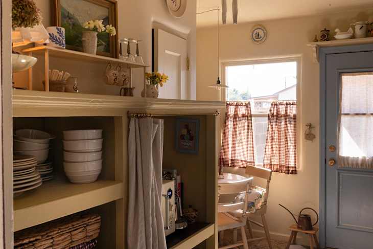Gingham cafe curtain in window of newly decorated farmhouse style kitchen.