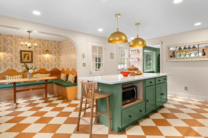Kitchen with green cabinetry, large island, and checkerboard floor after renovation.