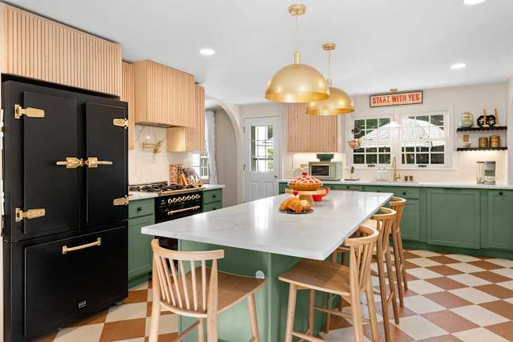 Kitchen with green cabinetry, large island, and checkerboard floor after renovation.