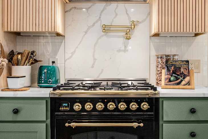 Kitchen with green cabinetry, large island, and checkerboard floor after renovation.