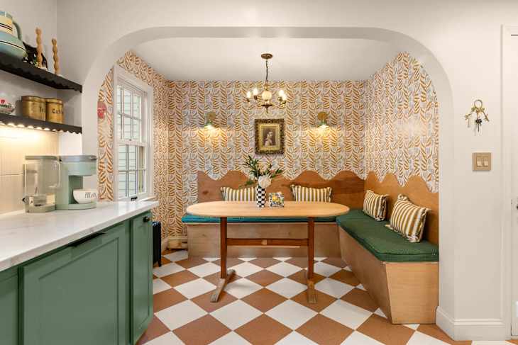 Kitchen with green cabinetry, large island, and checkerboard floor after renovation.