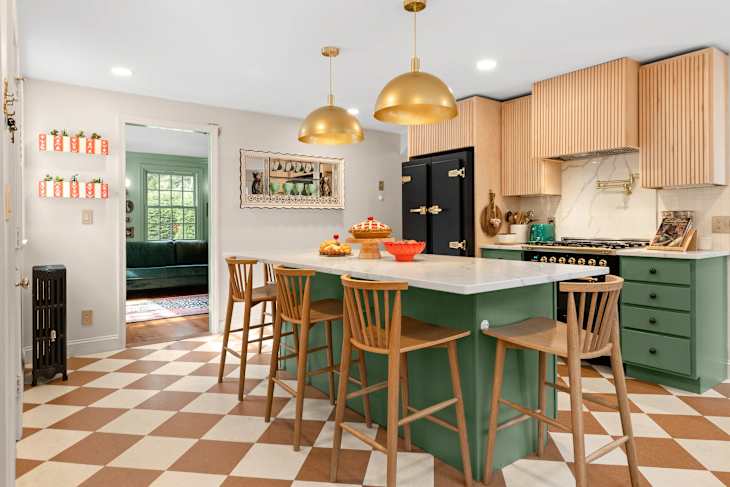 Kitchen with green cabinetry, large island, and checkerboard floor after renovation.