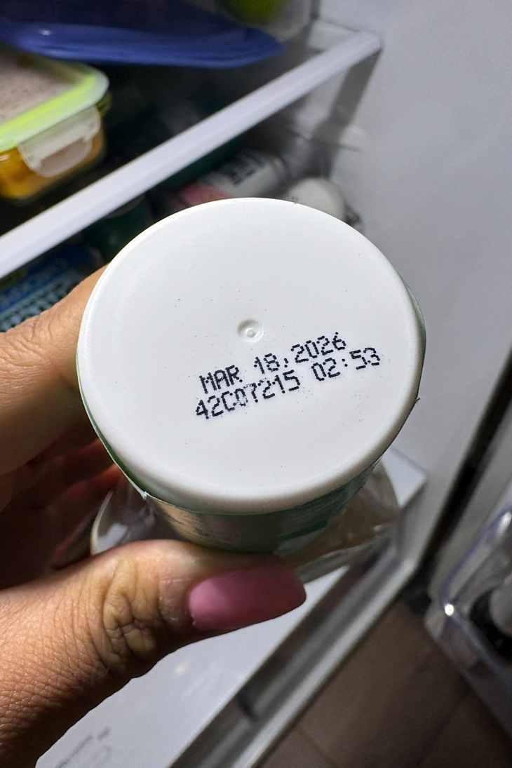 Expiration date on top of a Newman's Own Dressing bottle.