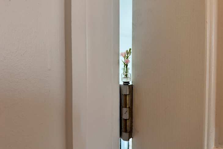 Miniature vase on as a door hinge topper.