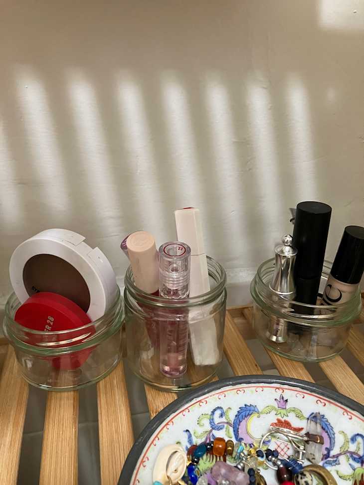 three glass jars filled with cosmetic products