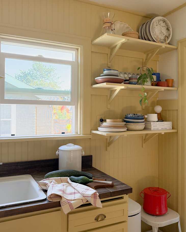 Servingware displayed on open kitchen shelves.