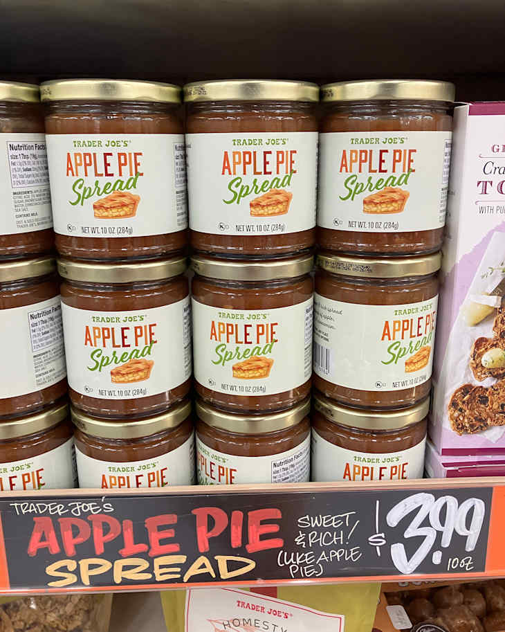 Jars of Trader Joe's Apple Pie Spread stacked on a shelf, with a price tag of $3.99.