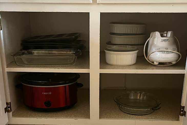 Organized kitchenware in cabinets after decluttering.