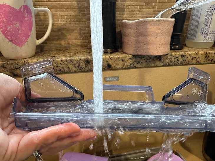 Someone rinsing component of Shark steam vac.