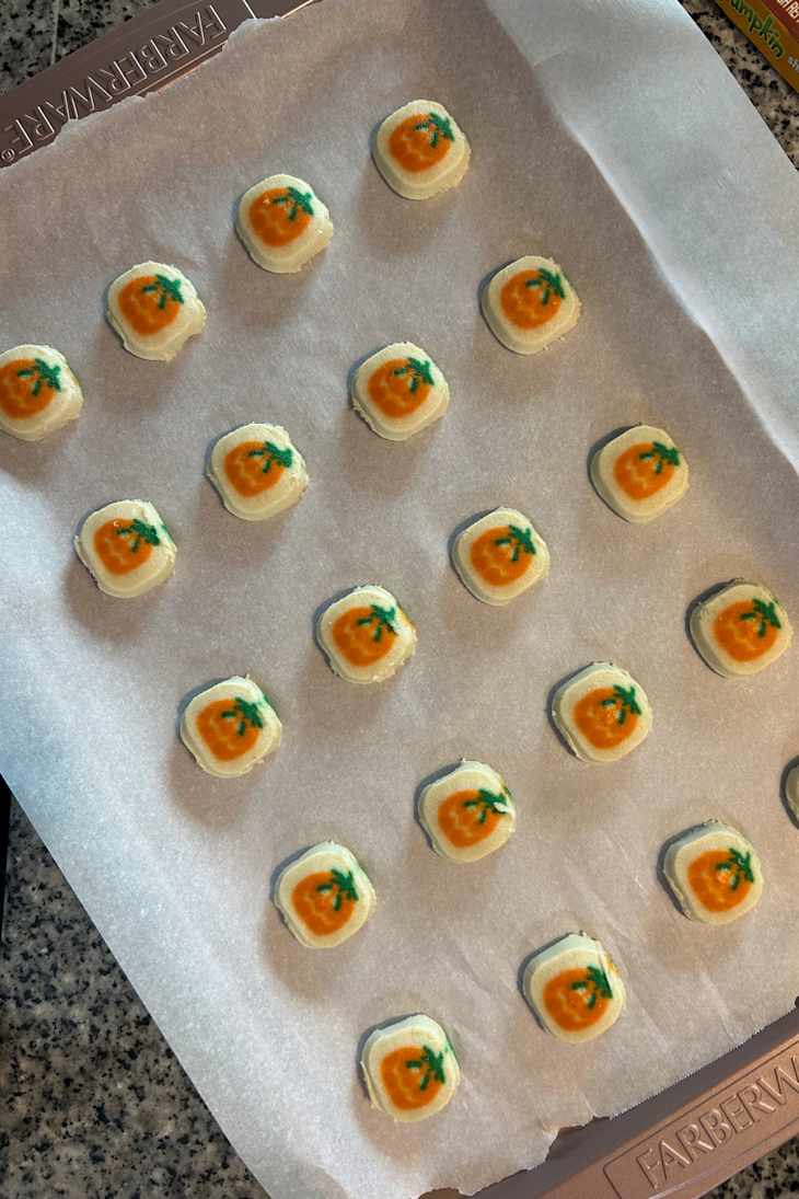 Colorful cookies shaped like squares with orange pumpkin designs.