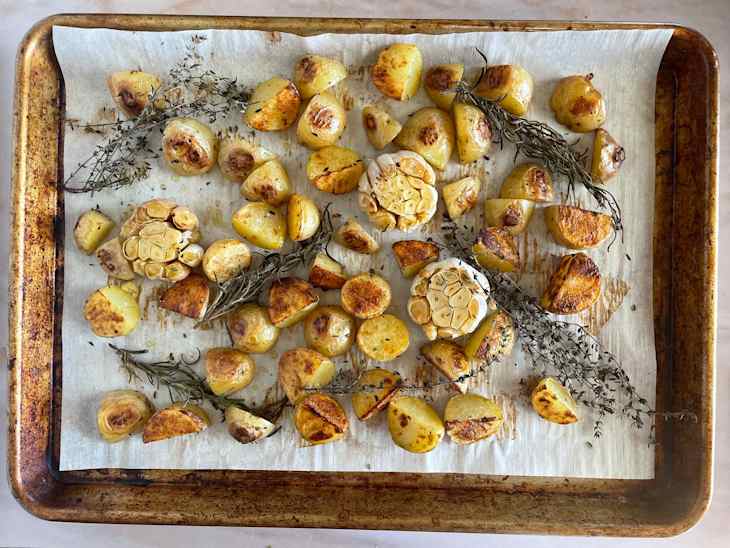 Roasted potatoes and garlic on sheet pan.