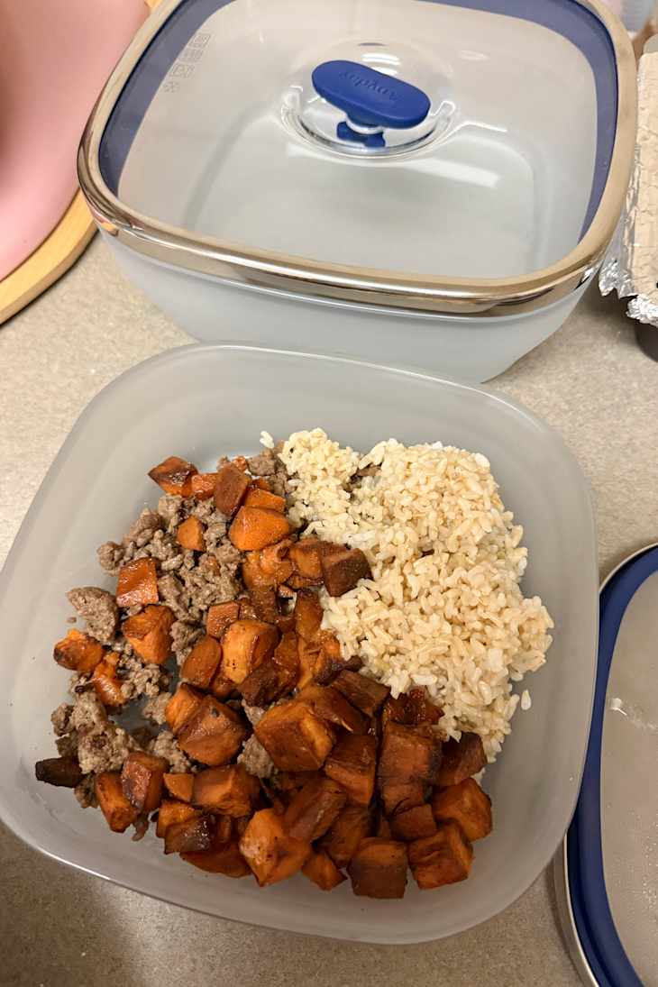 Cooked ground beef, roasted sweet potatoes, and brown rice in a clear container.