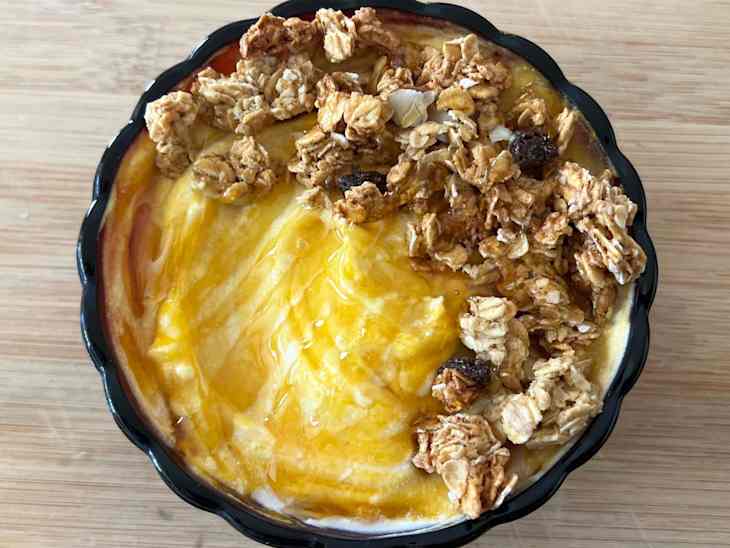 Pumpkin yogurt bowl on wooden surface.
