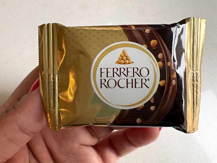 Someone holding Ferrero Rocher package.