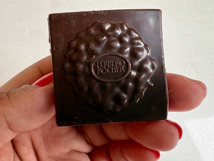 Someone holding Ferrero Rocher square.