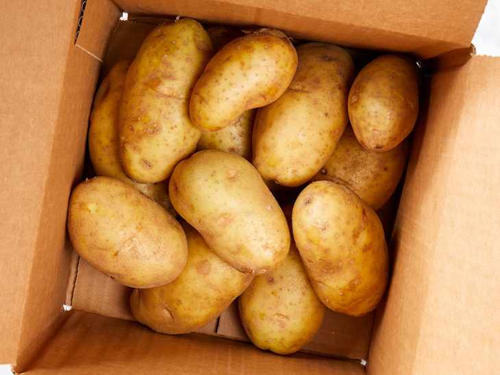 Overhead view of potatoes in a cardboard box.