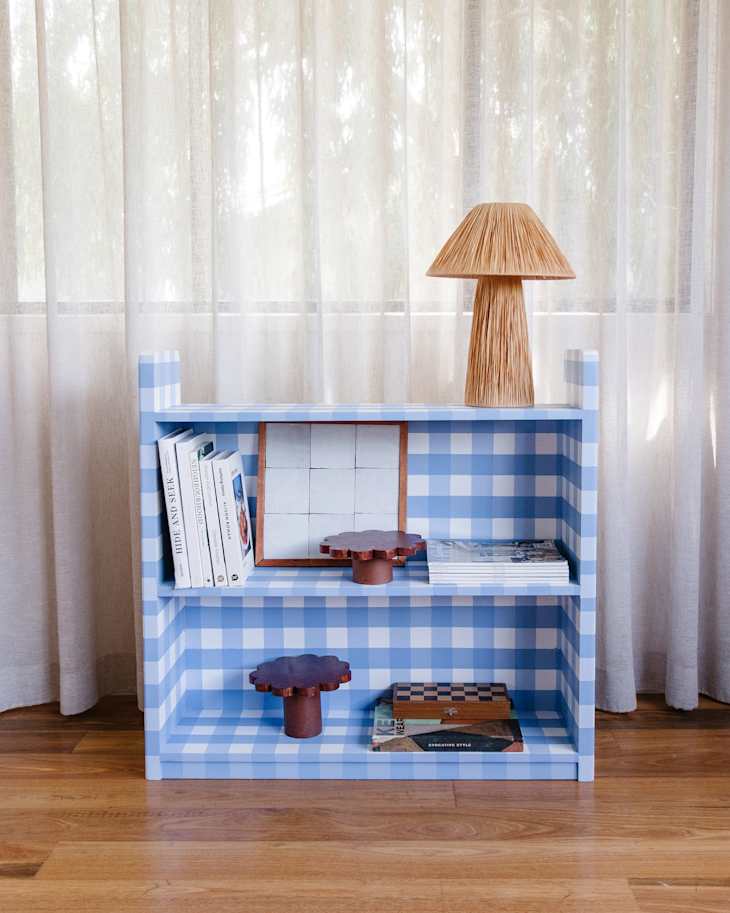 Blue and white checked contact paper on bookshelf.