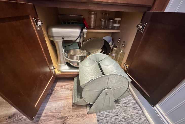 A cluttered kitchen cabinets with ferris wheel and other large items.