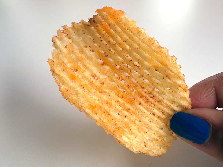 Someone holding up a Trader Joe’s Ketchup Flavored Lattice Potato Chip