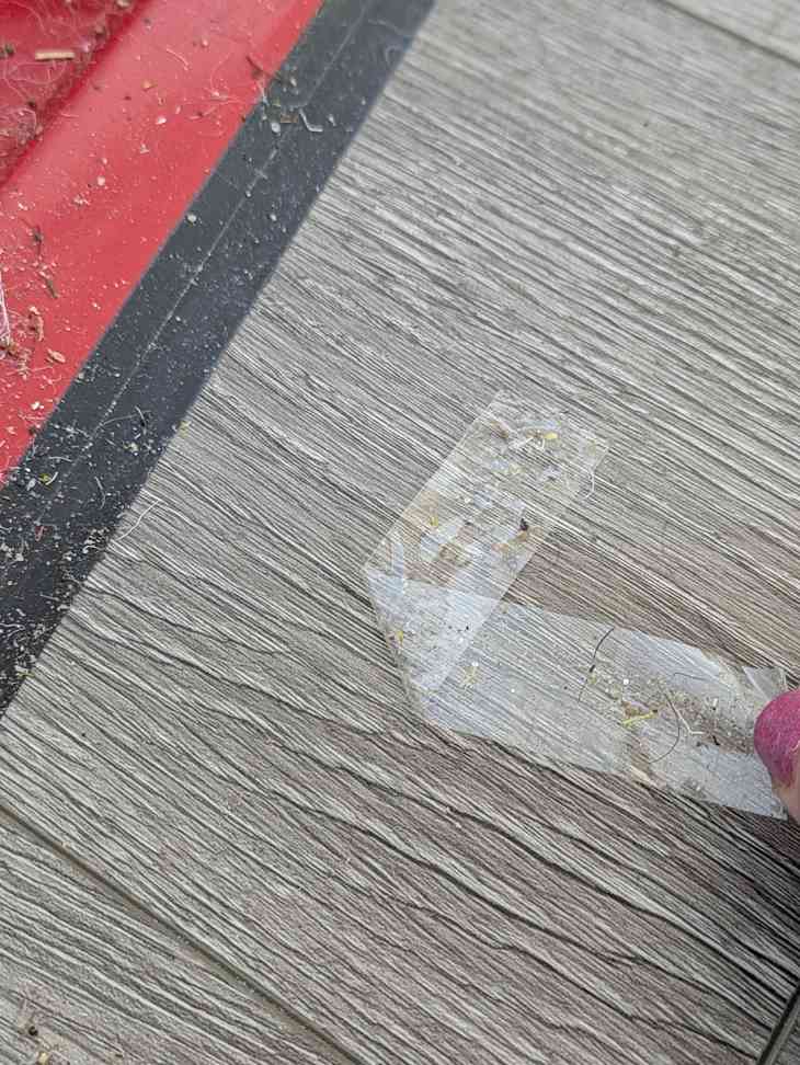 Someone using tape to keep up dust and debris from floor.