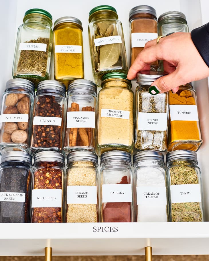 Someone gets fennel seeds from the drawer, and other spices are kept in a same drawer