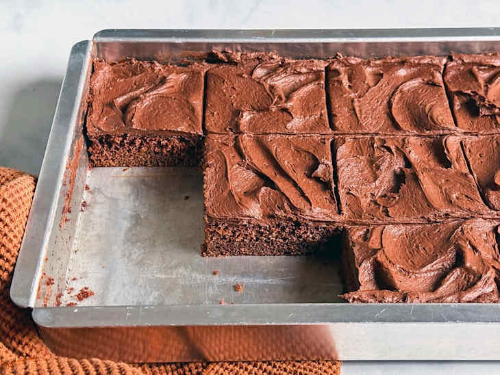 Sliced coca cola cake in sheet pan.