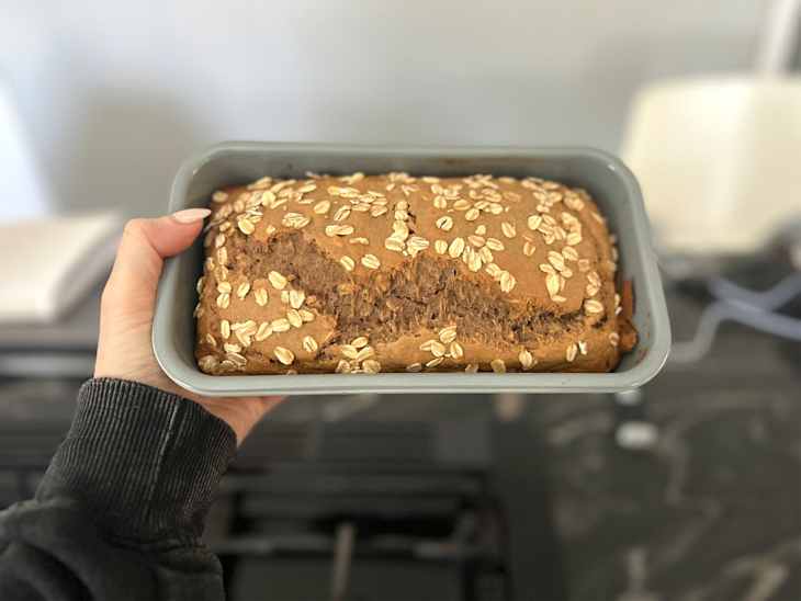 Someone holding Kodiak oat loaf in pan.