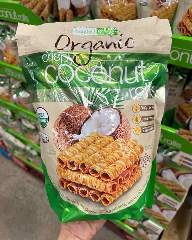 Organic coconut rolls package featuring crispy rolls, coconut images, and gluten-free labels, held in a hand.