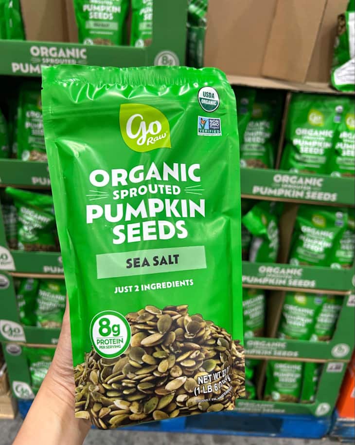 Organic sprouted pumpkin seeds in a green bag labeled "Sea Salt," showcasing nutritional information and ingredients.