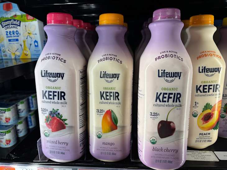 Three bottles of Lifeway Organic Kefir in mixed berry, mango, and black cherry flavors, displayed on a store shelf.