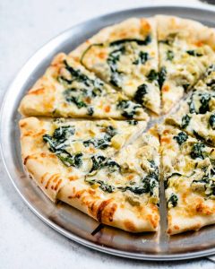 Pizza topped with Spinach and Artichokes